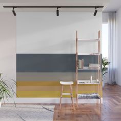 a living room with a wall painted in pastel colors and wooden flooring next to a window