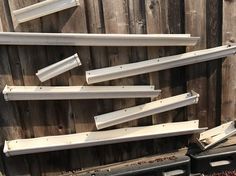 several pieces of wood sitting on top of a black box next to a wooden fence