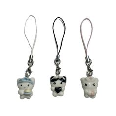 three different shaped key chains with charms attached to them, one has a tooth and the other has a bear on it