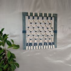 a blue and white wall hanging next to a potted plant