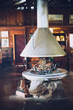 an old fashioned stove is in the middle of a room with wooden walls and ceilings