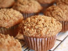 muffins cooling on a wire rack with some crumbs in the middle