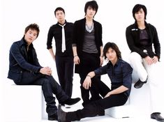 four young men are posing for a photo in front of a white background and one is wearing a black shirt