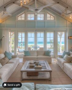 a living room filled with white furniture and lots of windows on top of the walls