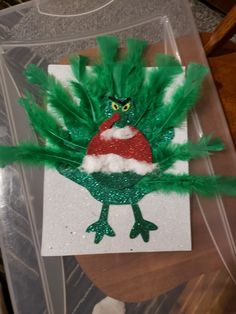 a piece of paper that has been made to look like a green bird with feathers on it