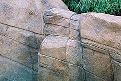 an elephant standing on top of a rock wall