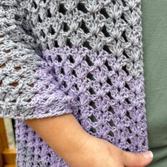 a close up of a person holding a crocheted blanket