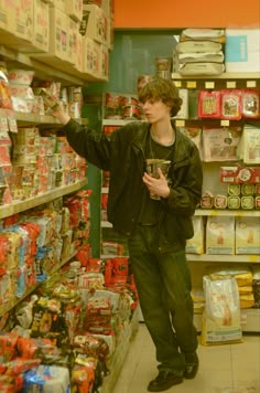 a young man is standing in the aisle of a store