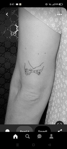 two hands holding each other tattoo on the right arm and left hand is shown in black and white