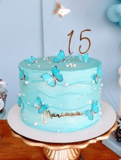 a blue birthday cake with butterflies on it