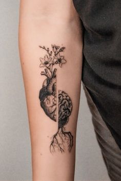 a person with a tattoo on their arm holding a flower in the shape of a heart