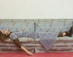 a woman laying on top of a couch