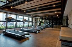 there are many treadmills in the room with glass walls and floor to ceiling windows