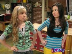 two young women standing next to each other in front of a kitchen counter with a brick wall