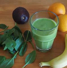 an avocado smoothie and oranges on a table