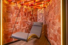 a hanging chair in the corner of a room with red brick walls and wooden flooring