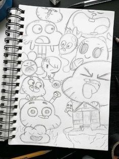 a drawing of angry birds on a notebook next to some markers and pencils,