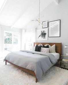 a bed room with a neatly made bed and pictures on the wall