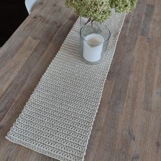 a vase filled with flowers sitting on top of a wooden table next to a glass of milk