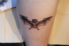 a small bat tattoo on the leg