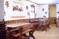 an empty restaurant with wooden tables and benches