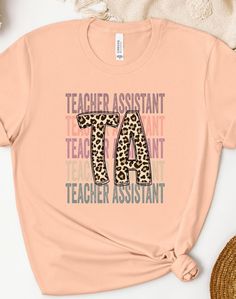 a pink t - shirt with the words teacher assistant and an animal print on it