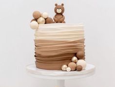 there is a cake that has two teddy bears on the top and bottom tiers