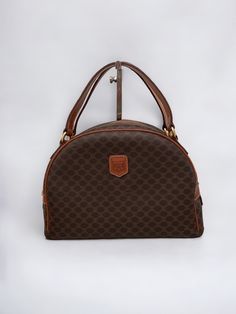 - Vintage * All items are pre-owned and show signs of wear or age - Authentic Celine Macadam Dome Handbag - Color: Brown - Exterior Material: PVC Leather - Interior Material: Leather - Hardware: Gold Tone - Interior Pocket: 1 - Size: W 11" H7.87" 3.93", W 28cm H20cm D10cm - Handle Drop: 11cm / 4.25"  - Country of Origin: Made in Italy - Condition:  Exterior Rank: [A] There is a stain in one spot on the handle. You can check it in the 8th image. Otherwise, there are no scratches, scuffs, hardware Celine Vintage Bag, Celine Vintage, Dome Bag, Top Handle Bags, Leather Hardware, Vintage Bags, Leather Interior, Purses And Handbags, Top Handle