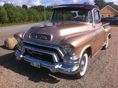 an old car is parked on the side of the road