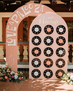 an arch with records on it and flowers in front of the entrance to a building