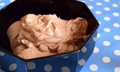 a bowl filled with ice cream on top of a blue polka dot covered tablecloth