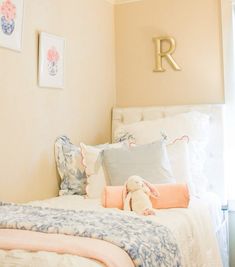 there is a bed with pillows and a stuffed animal on the headboard in this room