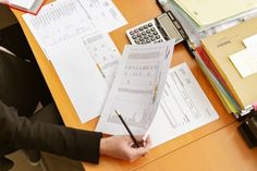 a person sitting at a desk with papers and calculator