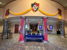 a banquet hall decorated with blue and yellow drapes, red curtains, and decorations