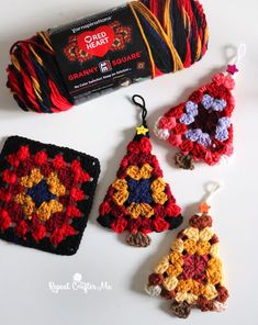 crochet christmas tree ornaments are displayed on a table next to a ball of yarn