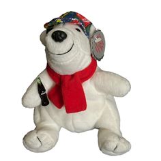 a white teddy bear wearing a red scarf and hat with a beer in it's mouth