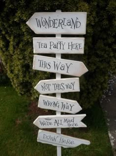 a wooden sign that says wonderland tea party here this way not this way wrong way we're all mad down here