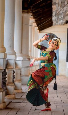 a woman in a colorful dress is dancing