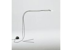 a black and white photo of a floor lamp with one light on it's side