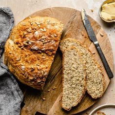 a loaf of bread sitting on top of a wooden cutting board next to some butter