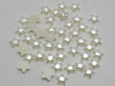 small white stars are scattered on a gray surface, as if they were made out of plastic