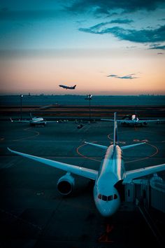 an airplane sitting on the tarmac at dusk