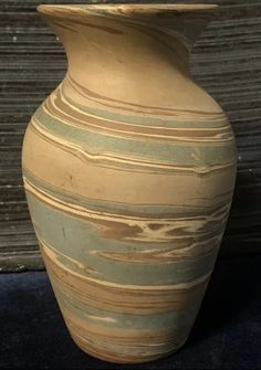 a large vase sitting next to a wooden wall