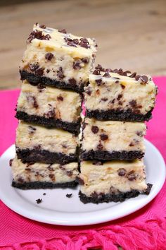 four pieces of chocolate chip cheesecake on a white plate with pink napkin and wooden table