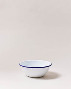 a white bowl with blue rim sitting on top of a table