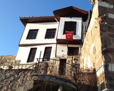 an old building with a flag hanging from it's balcony