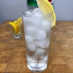 a glass filled with ice and lemon wedges