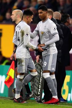 two soccer players talking to each other on the field