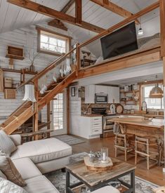 a living room filled with furniture and a flat screen tv on top of a wooden table