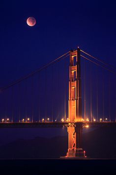 the moon is setting over the golden gate bridge